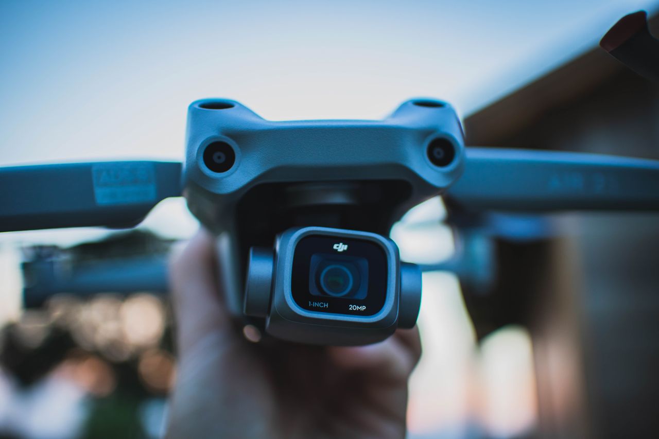 A camera drone held up before a flight